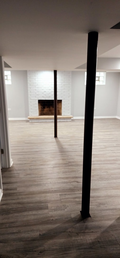 basement with dark hardwood / wood-style floors and a fireplace