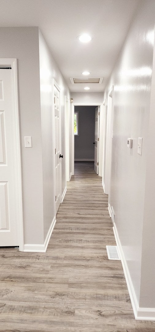 corridor with light hardwood / wood-style floors