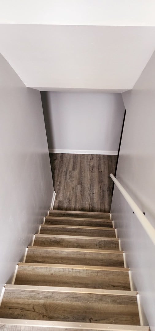 staircase with hardwood / wood-style floors