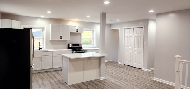 kitchen with white cabinets, a center island, sink, and stainless steel appliances