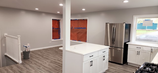 kitchen with stainless steel refrigerator, white cabinetry, and light hardwood / wood-style floors