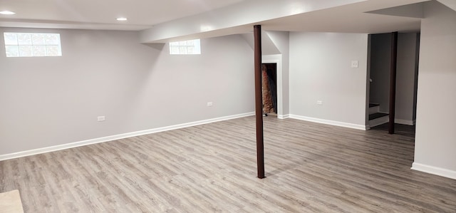 basement with a wealth of natural light and hardwood / wood-style flooring