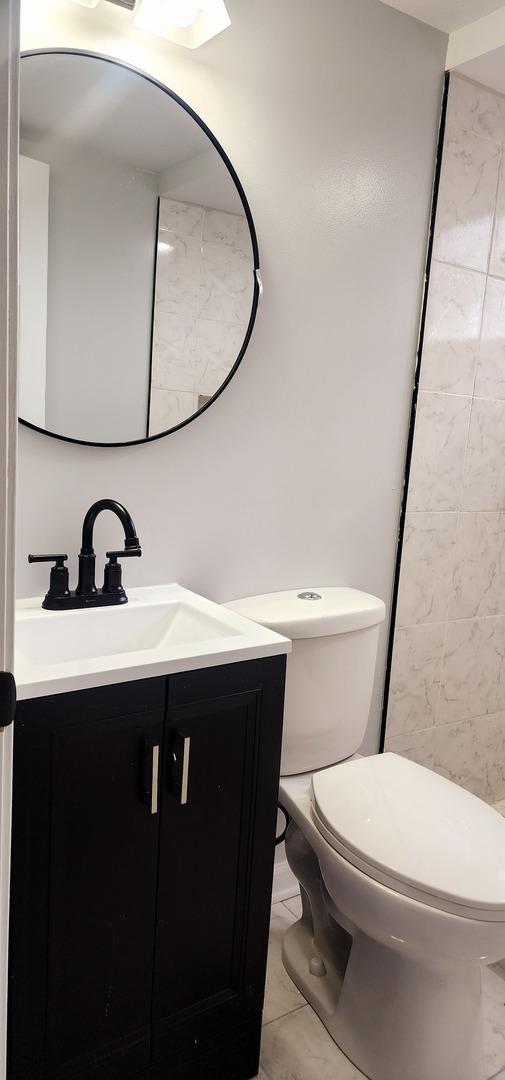 bathroom featuring tile patterned floors, vanity, and toilet