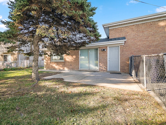 property entrance with a yard and a patio