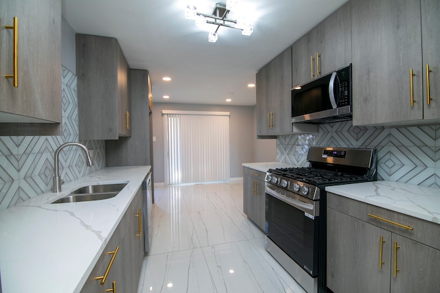 kitchen with gray cabinets, light stone countertops, sink, and stainless steel appliances