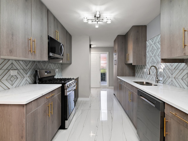 kitchen with appliances with stainless steel finishes, sink, tasteful backsplash, and light stone countertops