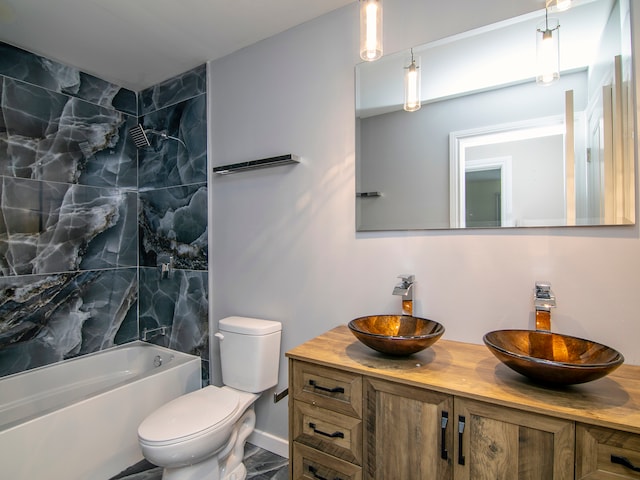 full bathroom with toilet, vanity, and tiled shower / bath