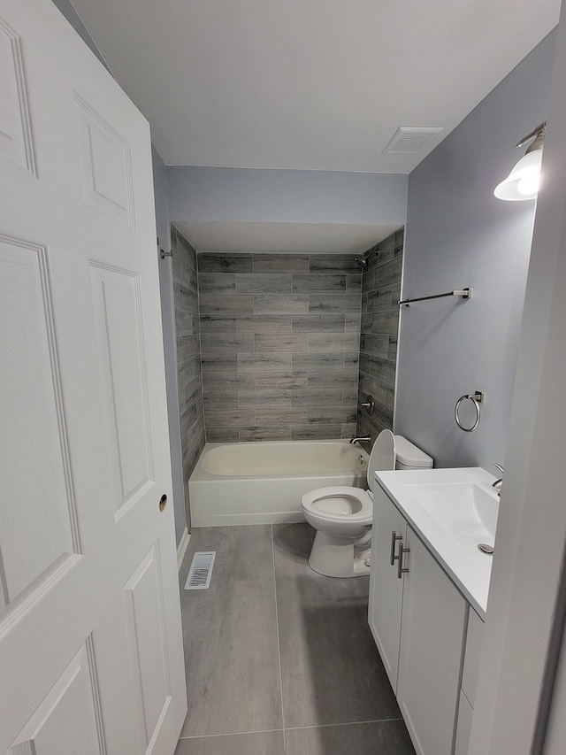 full bathroom featuring tile patterned flooring, vanity, toilet, and tiled shower / bath combo