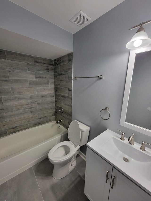 full bathroom with tiled shower / bath, tile patterned floors, toilet, and vanity