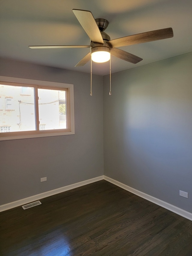 empty room featuring dark wood-type flooring and ceiling fan