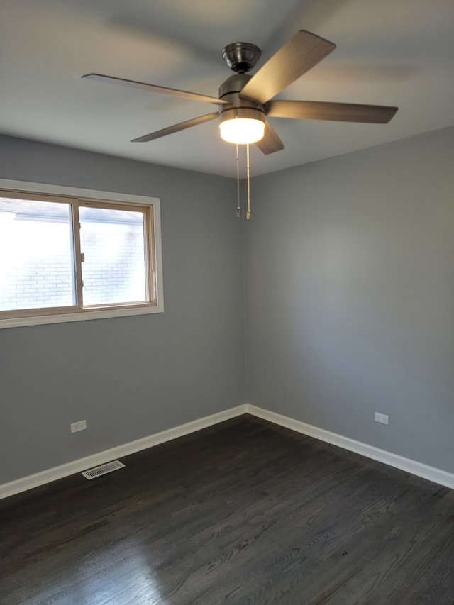 spare room with dark hardwood / wood-style flooring and ceiling fan