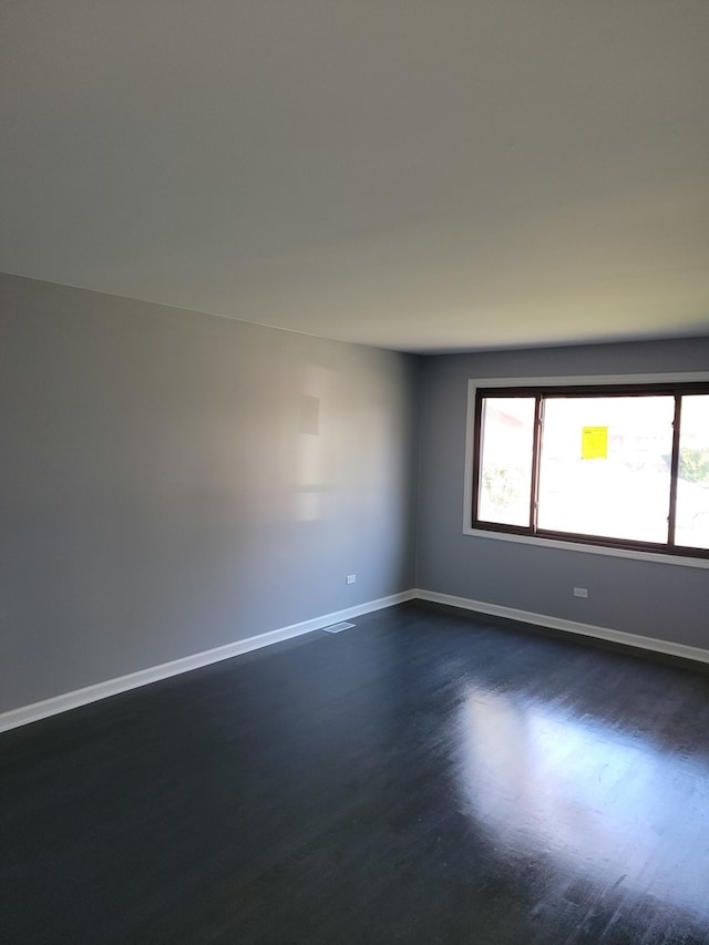 spare room featuring dark wood-type flooring