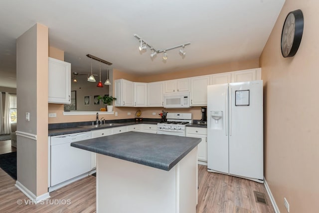 kitchen with pendant lighting, a kitchen island, white appliances, and white cabinetry