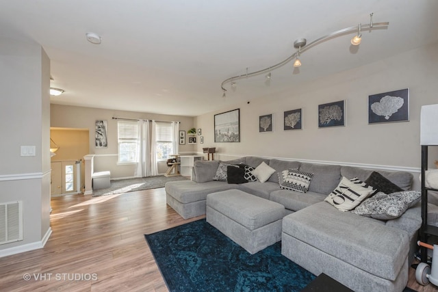 living room with wood-type flooring and rail lighting