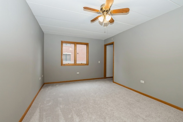 spare room featuring light carpet and ceiling fan