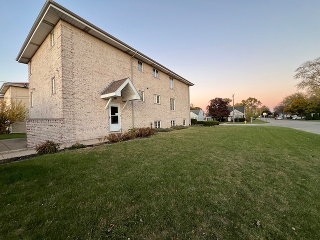 property exterior at dusk with a yard