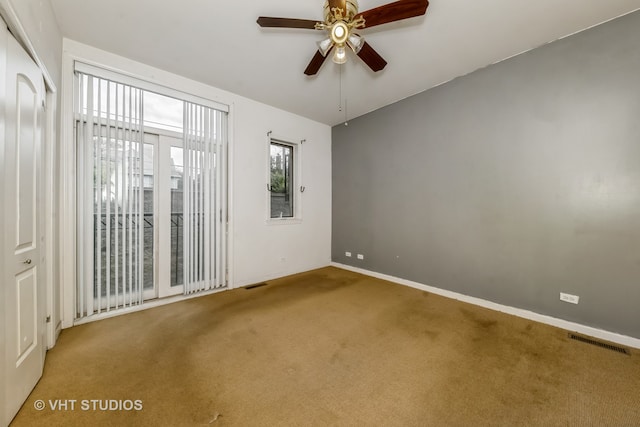 carpeted spare room with ceiling fan