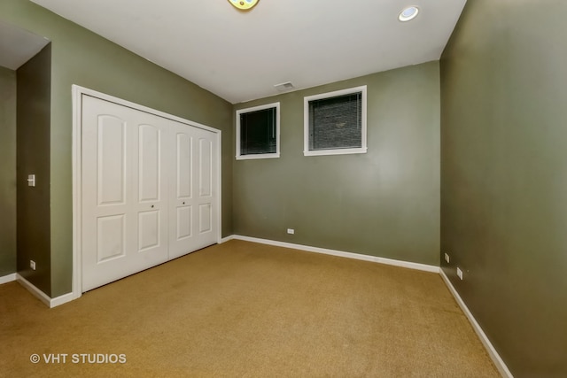 unfurnished bedroom featuring light carpet and a closet