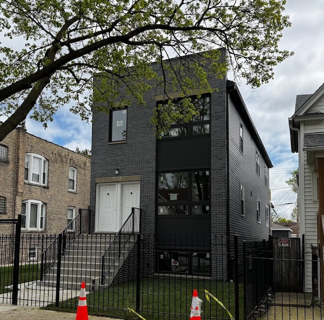 view of front of property featuring a fenced front yard and brick siding