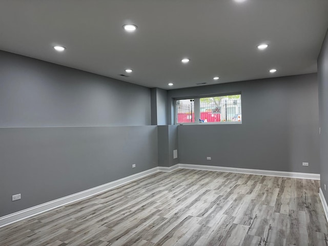 empty room featuring wood finished floors, recessed lighting, visible vents, and baseboards