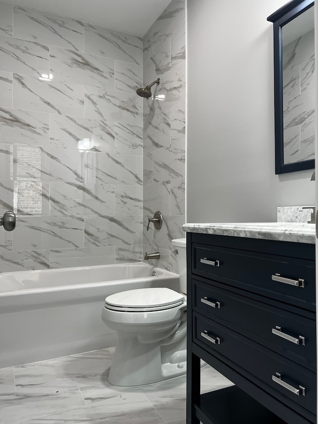 full bathroom featuring vanity, tiled shower / bath, and toilet