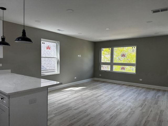 unfurnished living room with recessed lighting, visible vents, baseboards, and light wood-type flooring