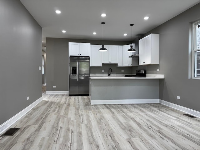 kitchen with visible vents, stainless steel appliances, a peninsula, and white cabinetry