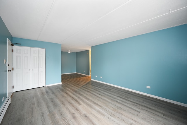 interior space with baseboard heating, light hardwood / wood-style flooring, and a closet