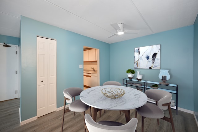 dining area featuring ceiling fan, dark hardwood / wood-style floors, and sink