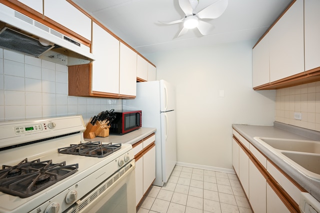 kitchen with white cabinetry, light tile patterned flooring, white appliances, and backsplash