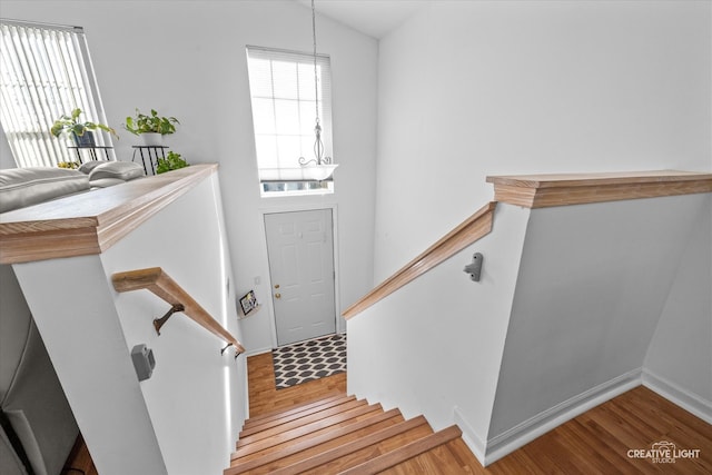 stairway with hardwood / wood-style floors and vaulted ceiling