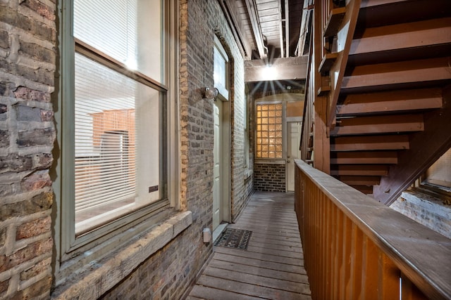 interior space featuring dark hardwood / wood-style flooring and brick wall