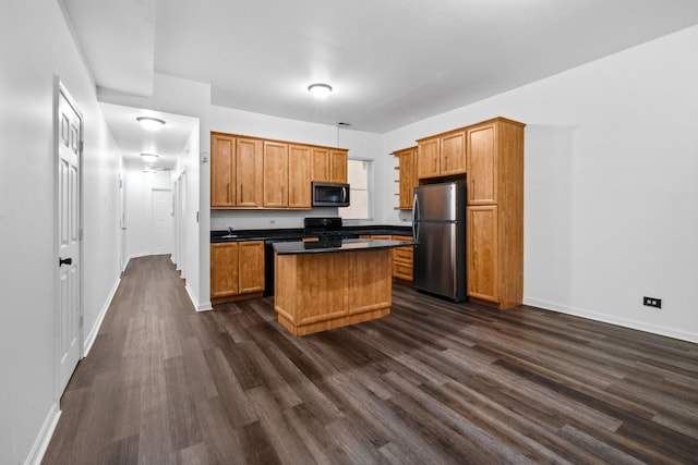 kitchen featuring appliances with stainless steel finishes, dark hardwood / wood-style flooring, a kitchen island, and sink