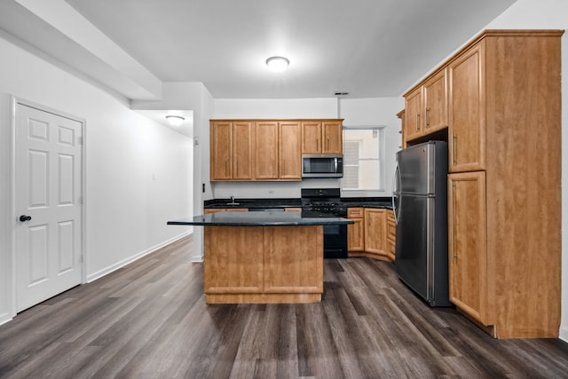 kitchen with a kitchen island, dark wood-type flooring, and appliances with stainless steel finishes