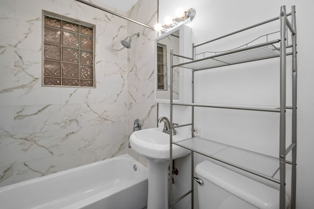 full bathroom featuring toilet, tiled shower / bath, and sink