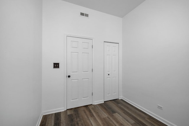 unfurnished bedroom featuring two closets and dark hardwood / wood-style floors