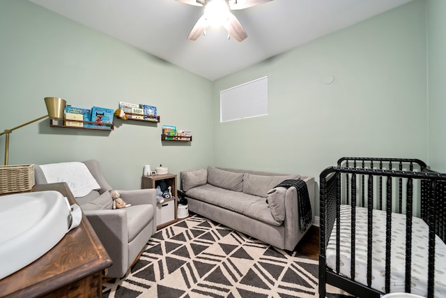 bedroom with a nursery area, sink, and ceiling fan