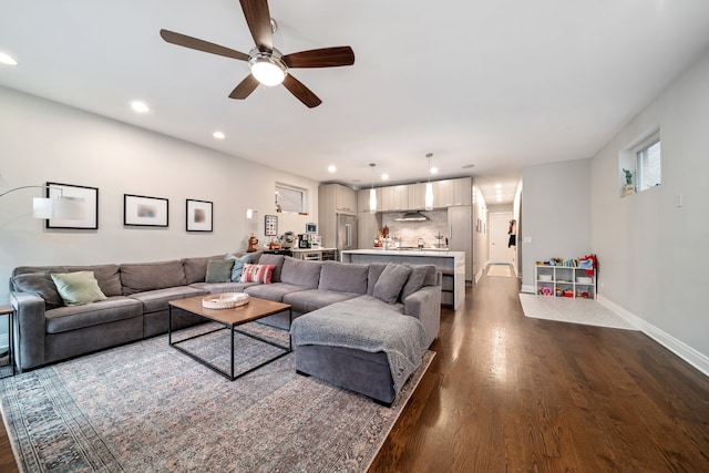 living room featuring dark wood-type flooring and ceiling fan