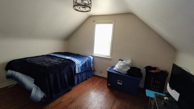 bedroom with dark hardwood / wood-style floors and lofted ceiling