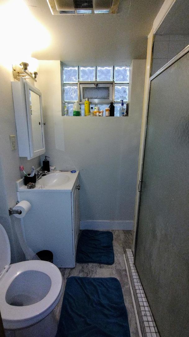 bathroom featuring tile patterned floors, vanity, and a shower with door