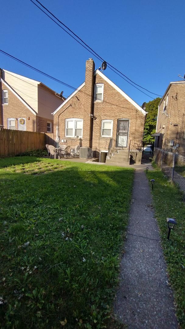 back of house featuring a lawn