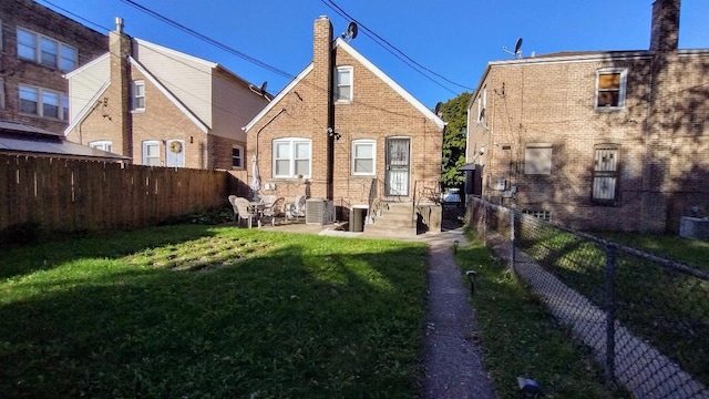 rear view of house featuring a lawn and a patio area