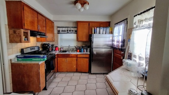 kitchen with backsplash, sink, stainless steel refrigerator, and electric range