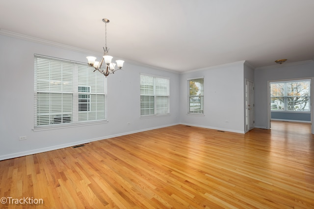 empty room with ornamental molding, a healthy amount of sunlight, and light hardwood / wood-style flooring