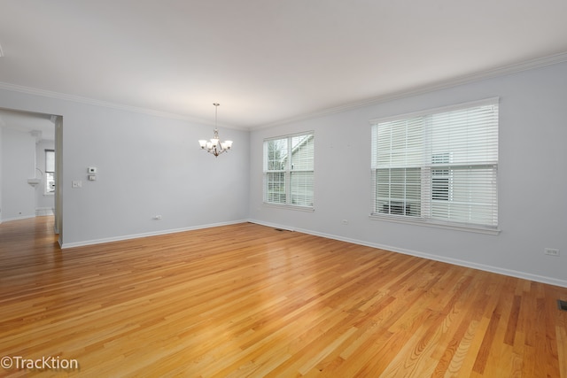 unfurnished room featuring light wood-type flooring, a chandelier, and crown molding