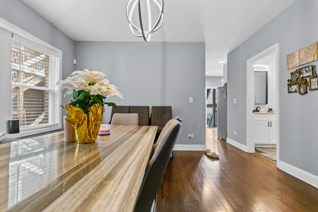 dining space with an inviting chandelier, dark wood-type flooring, and sink