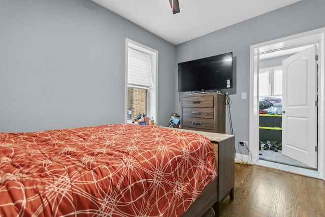 bedroom with multiple windows, ceiling fan, and dark wood-type flooring