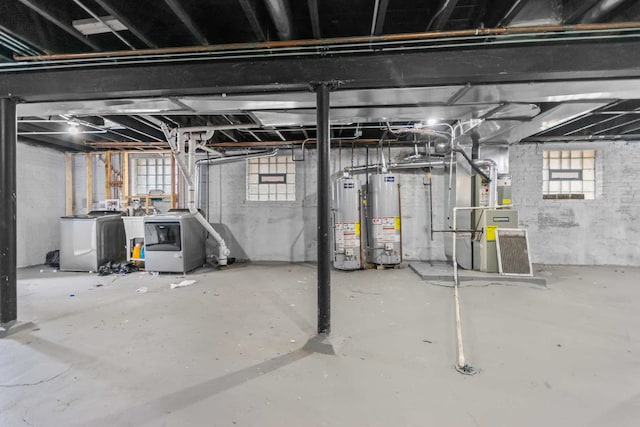 basement with washing machine and dryer, heating unit, and water heater