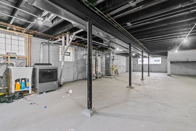 basement with heating unit, washer / clothes dryer, and water heater