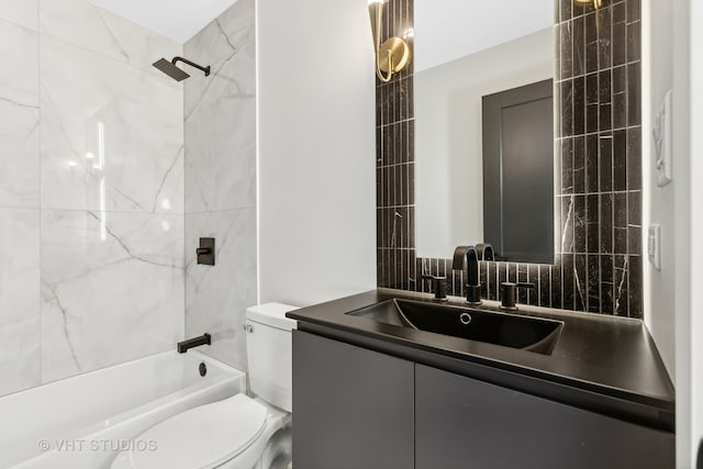 full bathroom featuring tiled shower / bath, vanity, and toilet